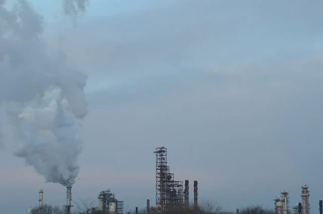 ExxonMobil refinery in Joliet, Illinois, with industrial structures and smoke.