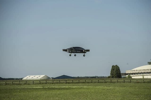 Vertical Aerospace eVTOL prototype aircraft in flight over a grassy field.