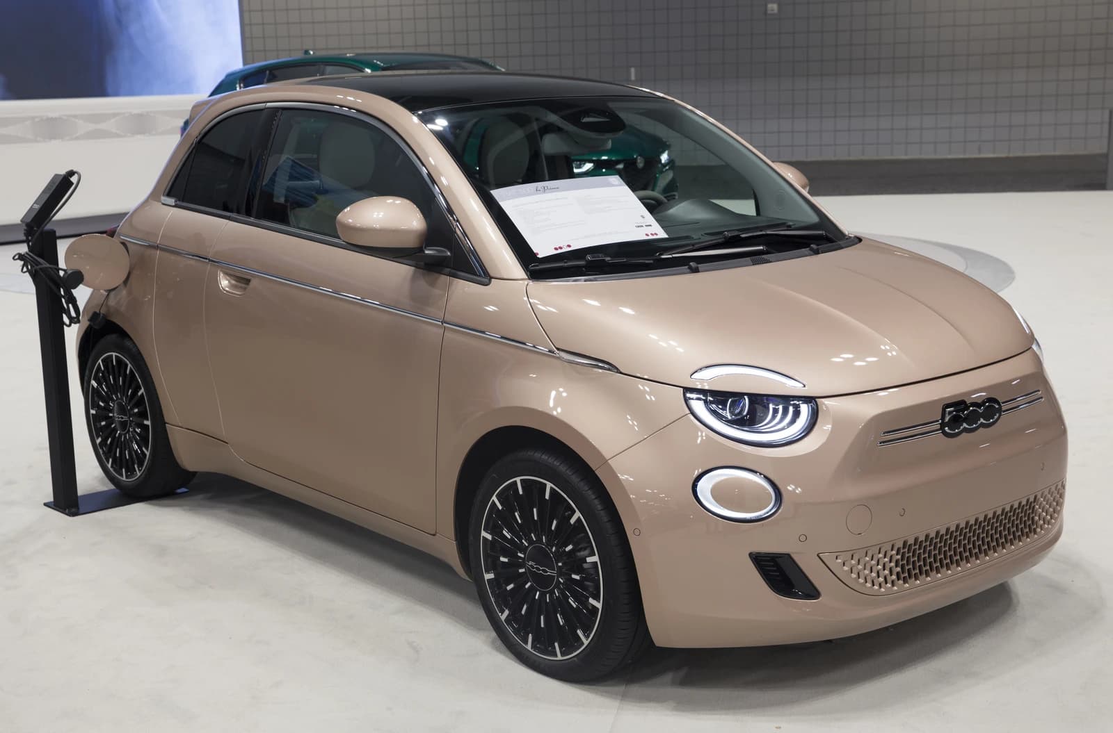 A beige 2022 Fiat 500e 3+1 La Prima electric car on display.