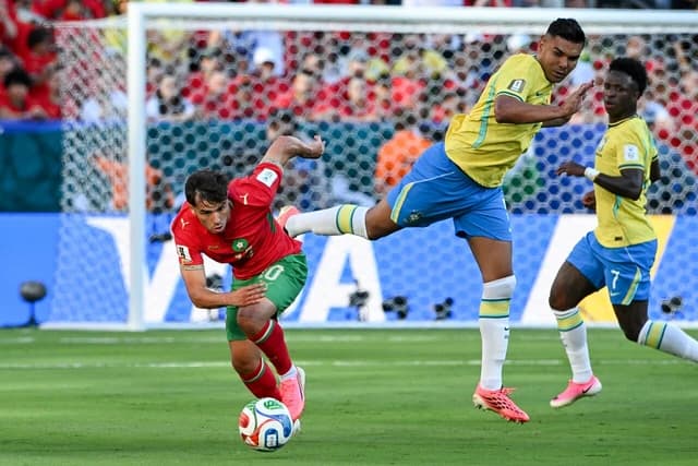 Casemiro, a football player, attempts to kick a football during a game.