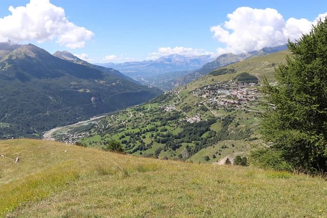Panoramic view of Orcières Merlette 1850 ski resort nestled in a green mountain valley.