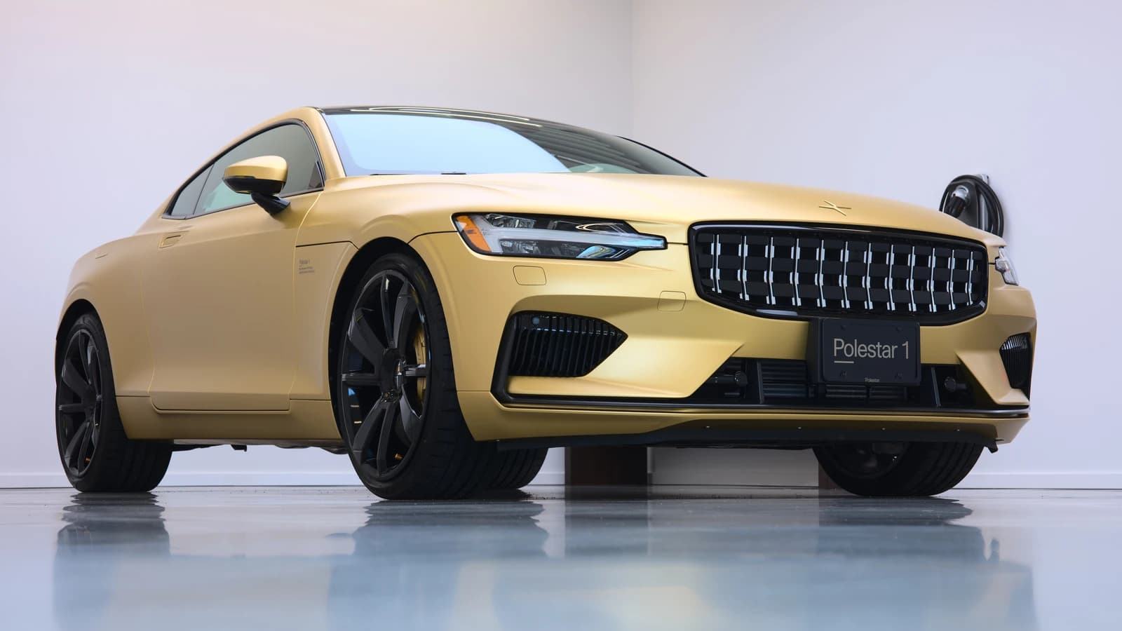A gold Polestar 1 plug-in hybrid electric vehicle on display.