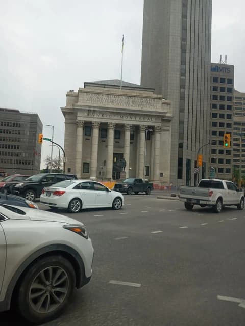 Bank of Montreal building with neoclassical architecture on a city street corner.
