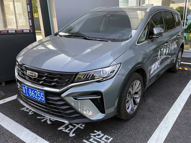 A grey Geely Jiaji L test drive vehicle parked in a paved lot.