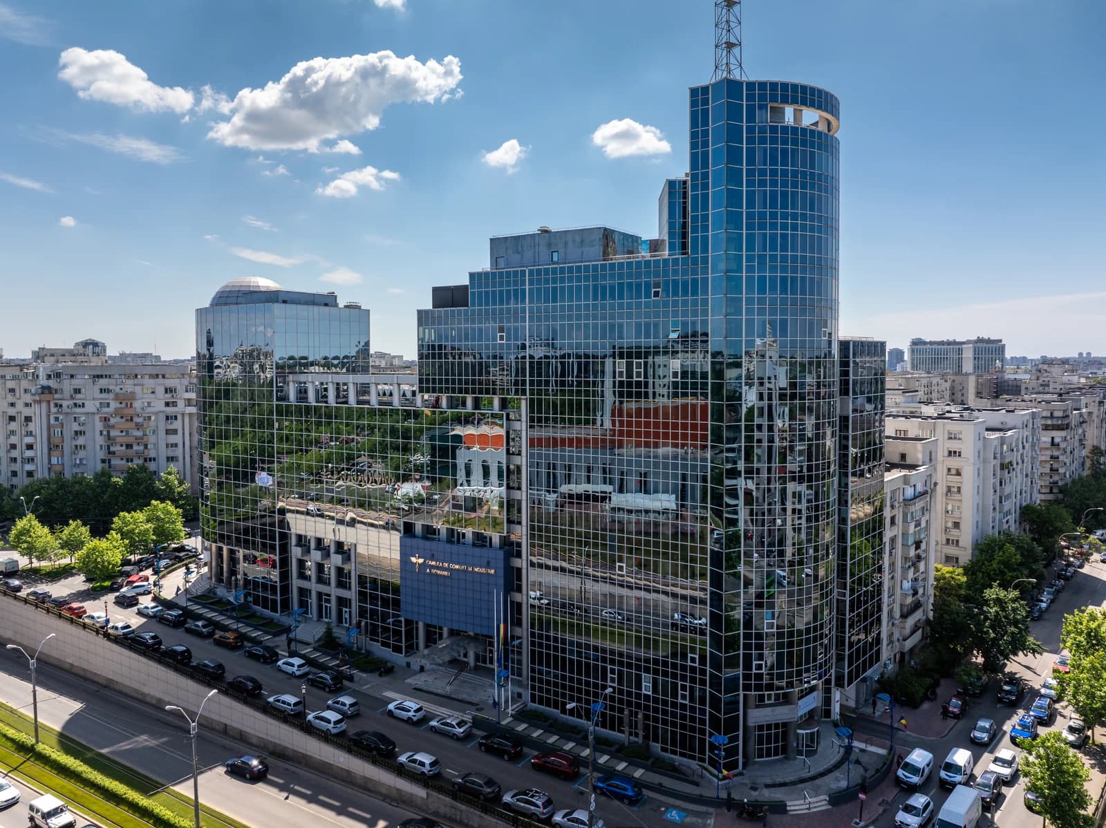 Aerial view of the glass-fronted CCIR building in Bucharest, Romania, with a street and cars.