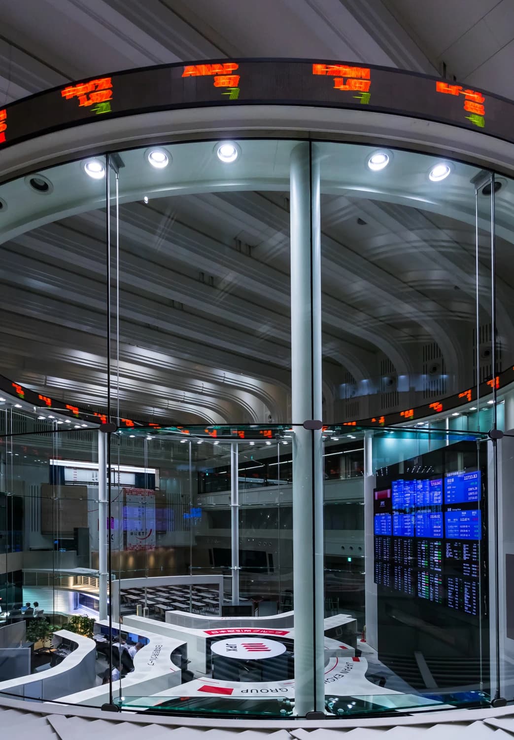 Interior of the Tokyo Stock Exchange main trading floor with digital displays.