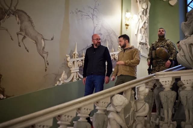 Ukrainian President Volodymyr Zelenskyy speaking with an official inside a building.