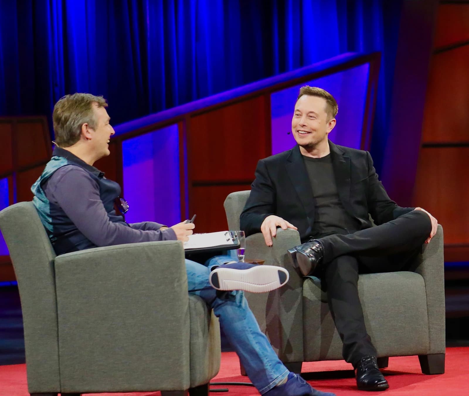 Elon Musk, CEO of Tesla, sitting on stage during a conversation at TED 2017.