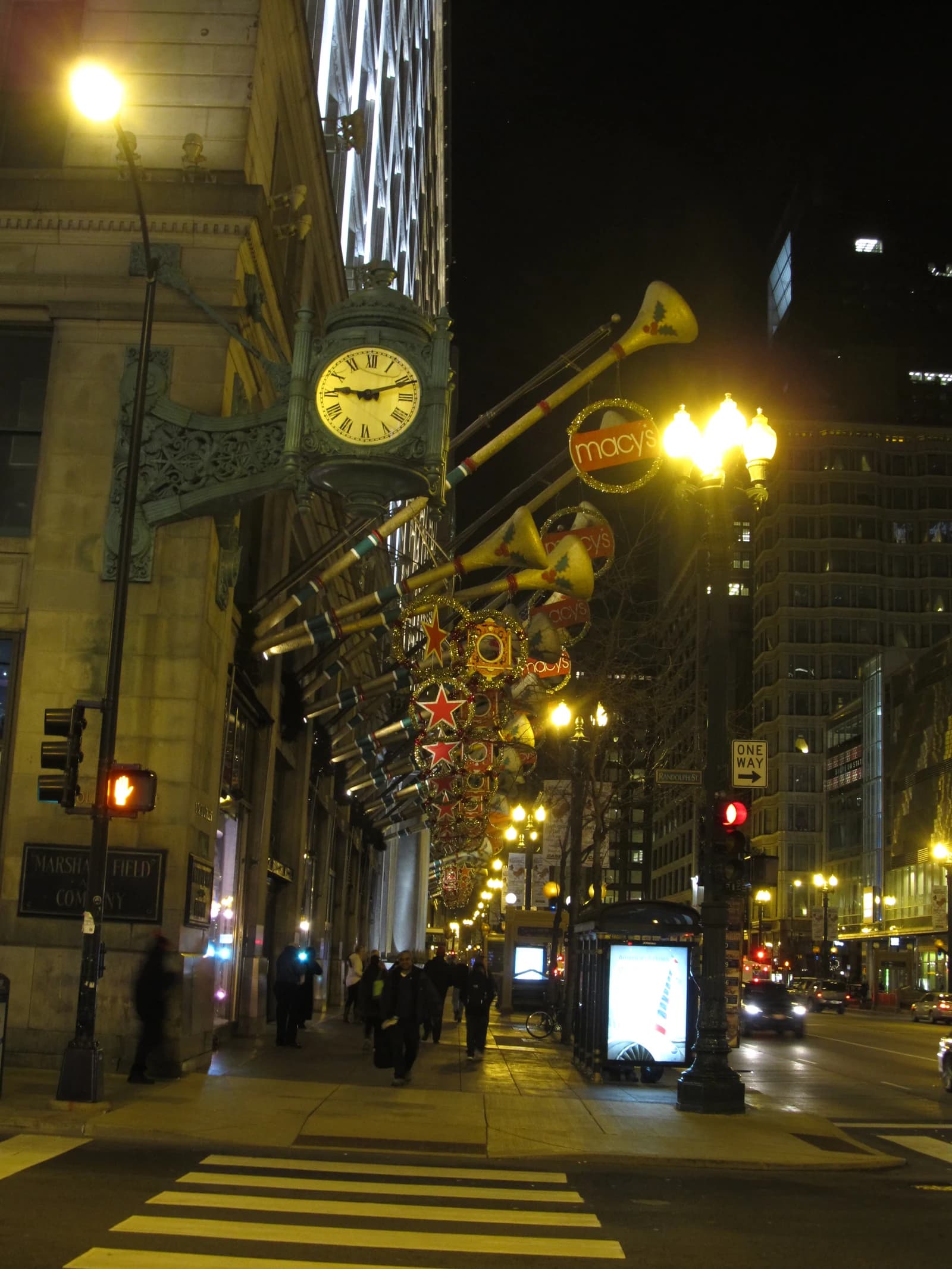 Macy's Christmas decorations and street lights illuminate the Marshall Field building in Chicago at night.