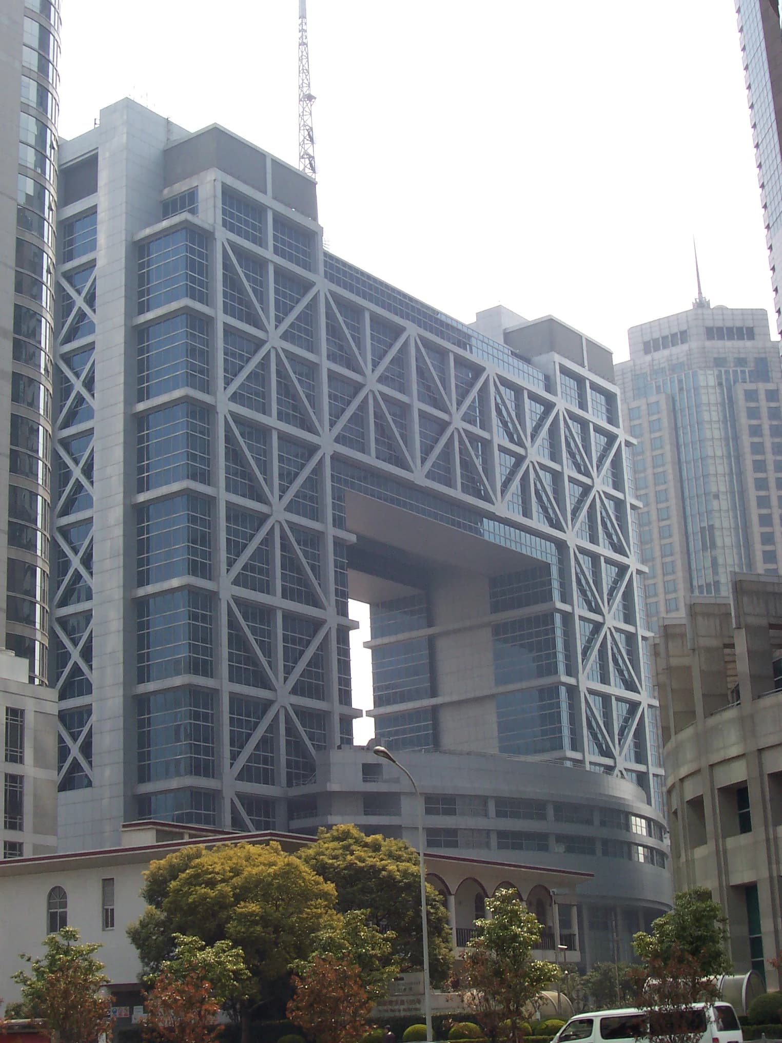 The modern Shanghai Stock Exchange Building, a large gray and glass structure, stands tall in Pudong.