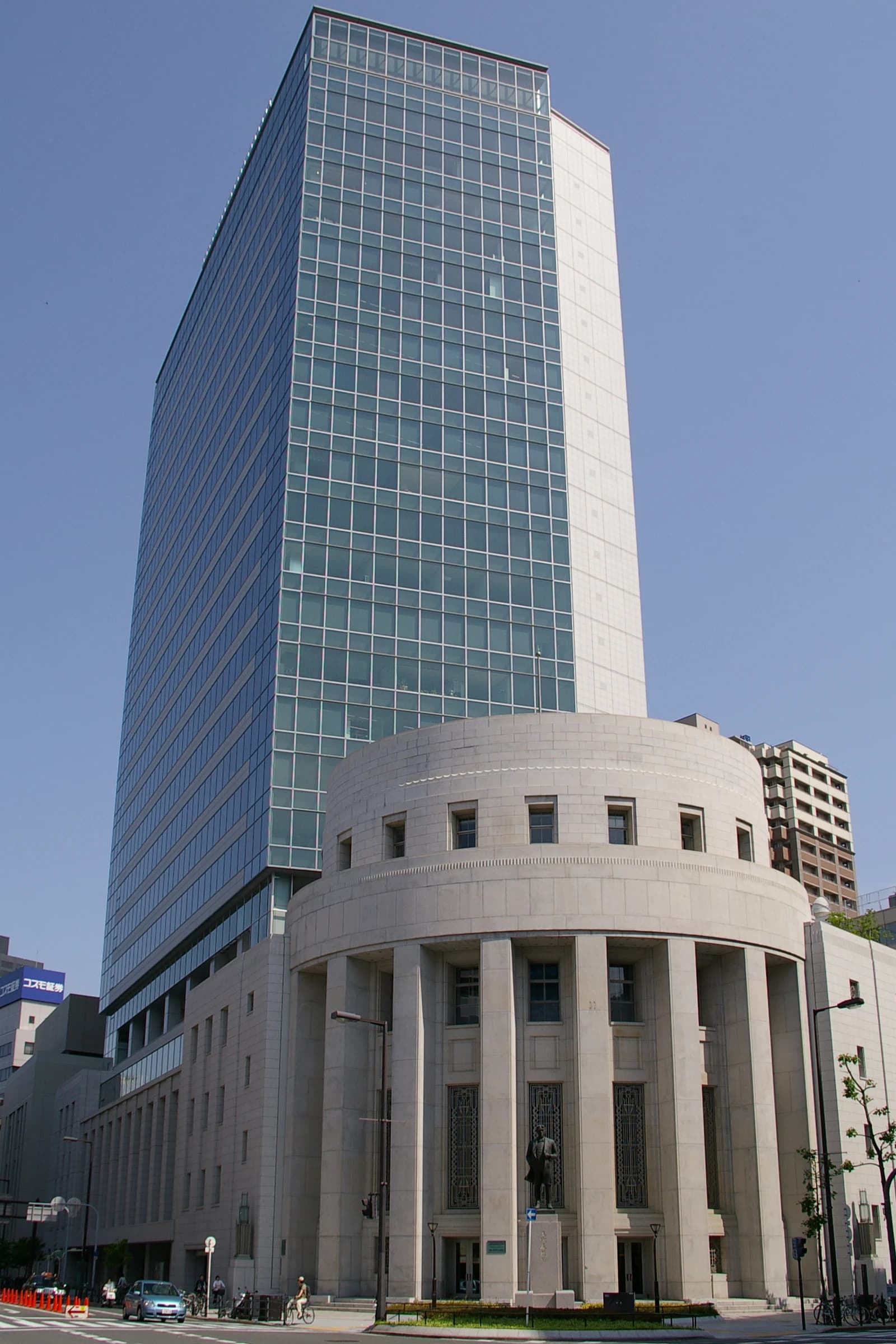 Exterior of the Osaka Securities Exchange building under a clear blue sky.