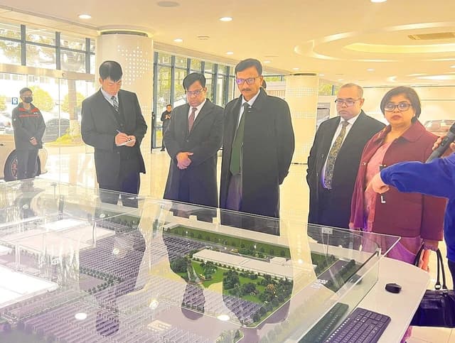 Md Touhid Hossain, Foreign Advisor, observing a model of an electric vehicle factory.