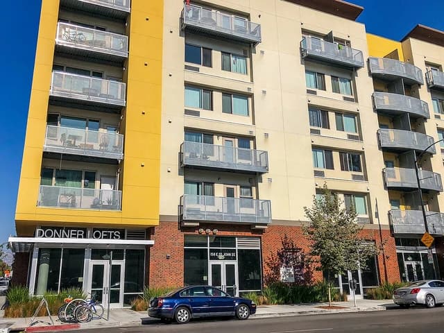 Donner Lofts affordable housing building with balconies and a car parked on the street in San Jose.