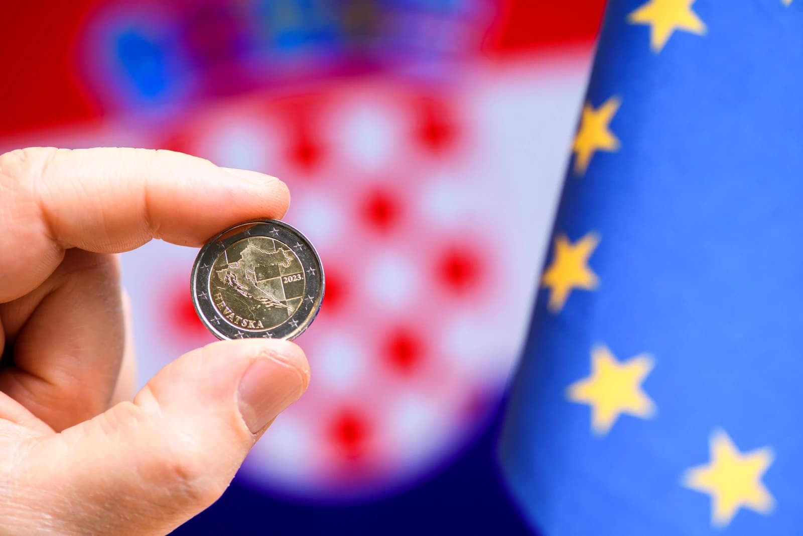 Hand holding a 2023 Croatian euro coin with Croatian and European Union flags.