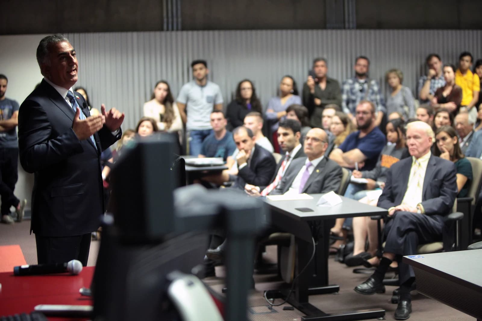 Reza Pahlavi, son of the former Shah of Iran, speaking to an audience indoors.