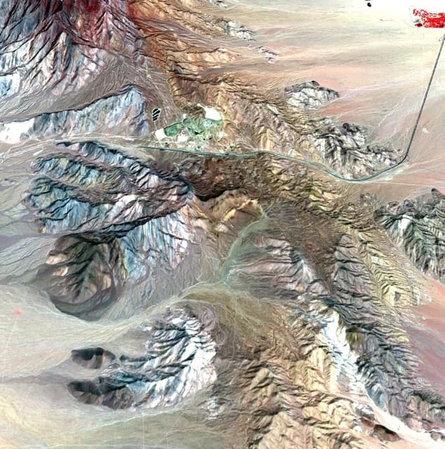 Satellite image of the Mountain Pass Mine in California, surrounded by mountainous terrain.