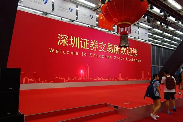 Interior of the Shenzhen Stock Exchange hall with a red stage and welcome sign.