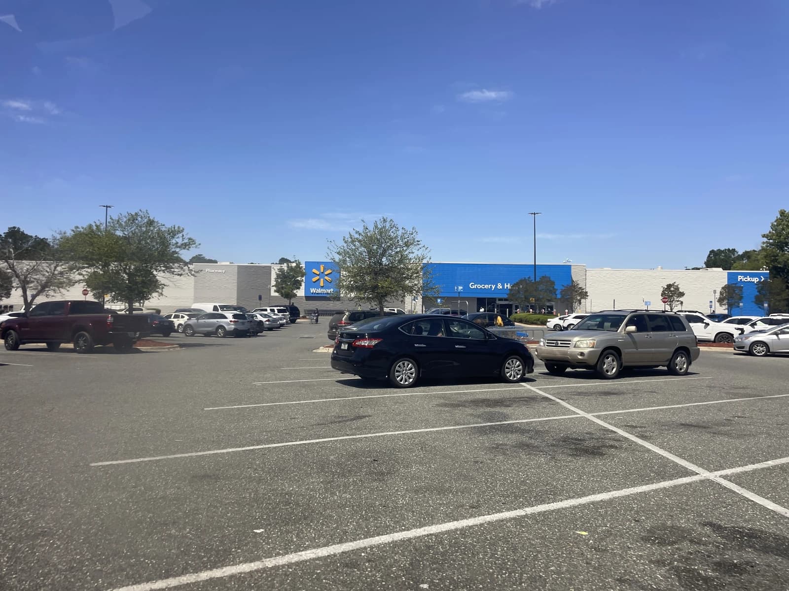 Exterior of a Walmart Supercenter building with a parking lot full of cars.