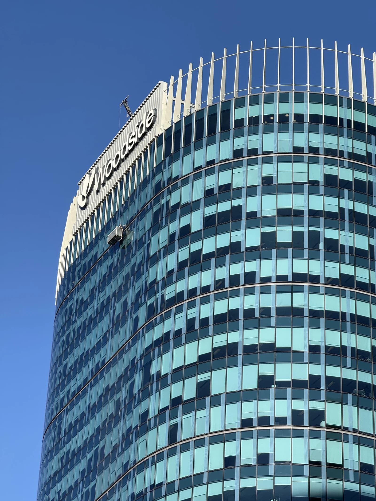 Woodside Energy Headquarters building in Perth, Western Australia, under a clear sky.
