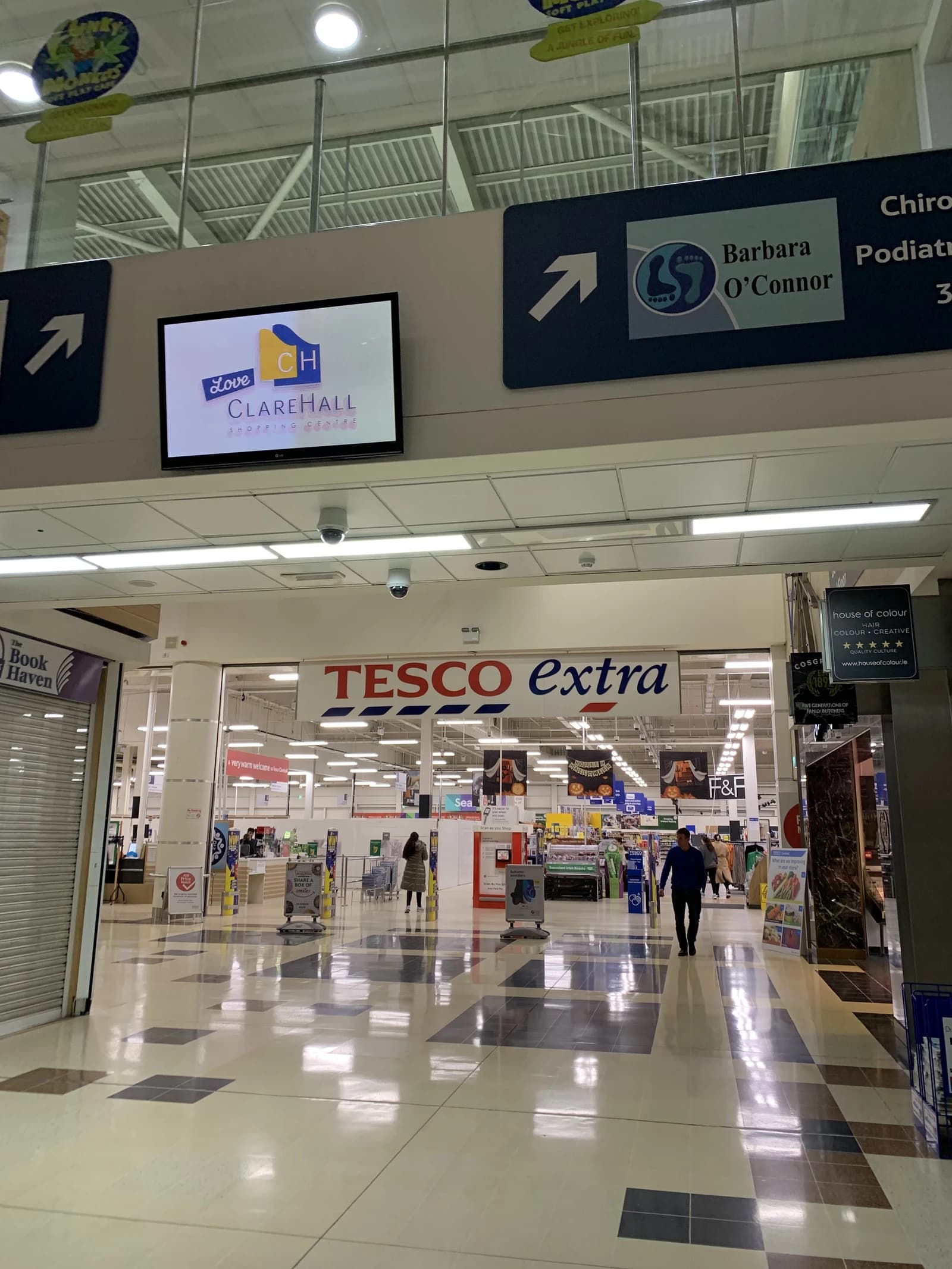 Entrance to Tesco Extra supermarket in Clarehall Shopping Centre, showing signage and shoppers.