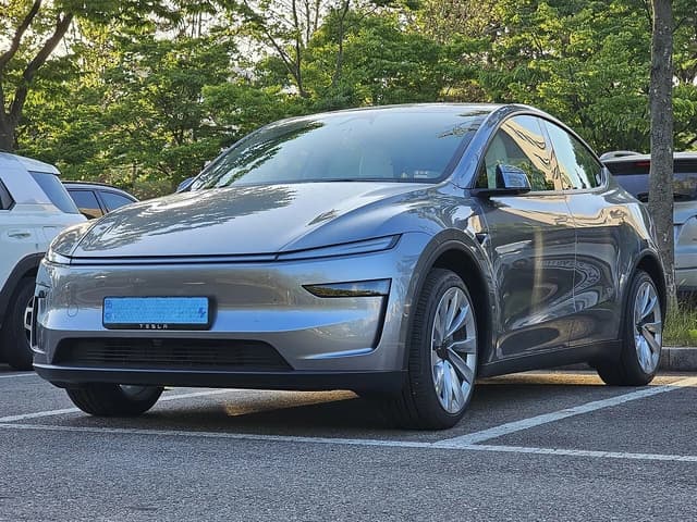 Tesla Model Y Dual Motor First Edition Juniper Quicksilver parked in a lot.