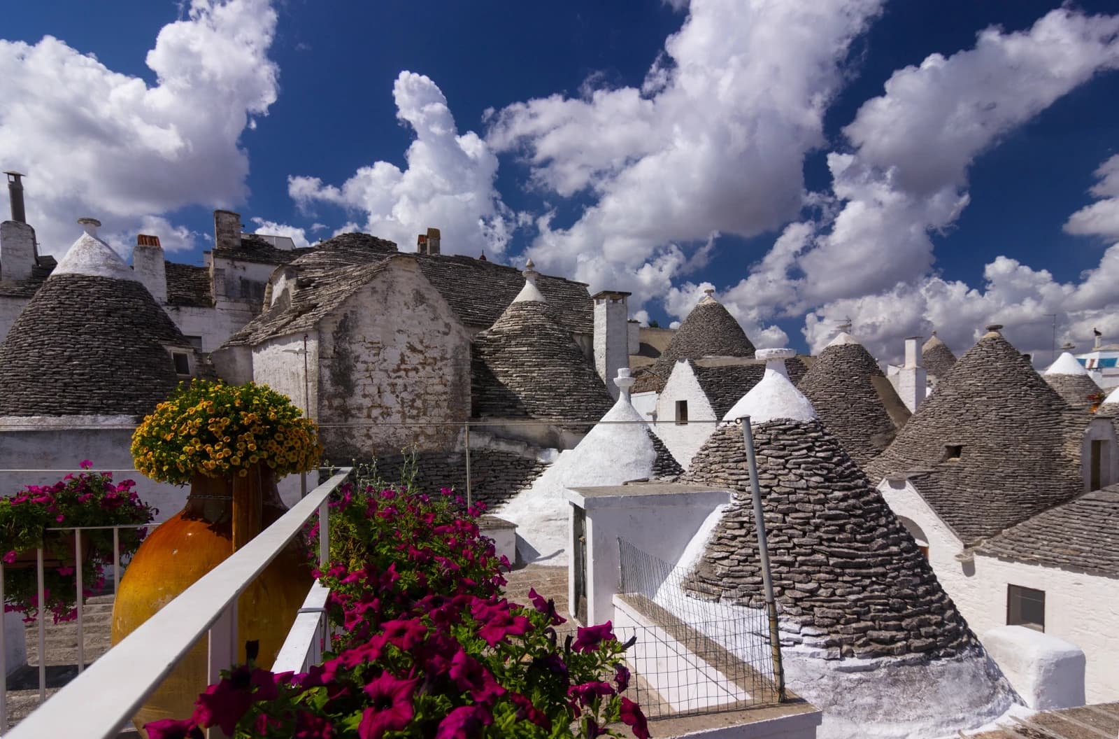 Trulli houses in Puglia with white walls and grey conical stone roofs.