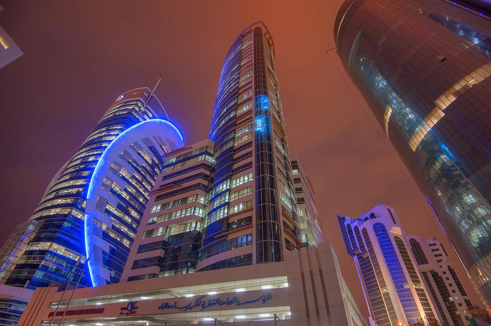 Kahramaa Headquarters building at night, illuminated with blue lights in Doha, Qatar.