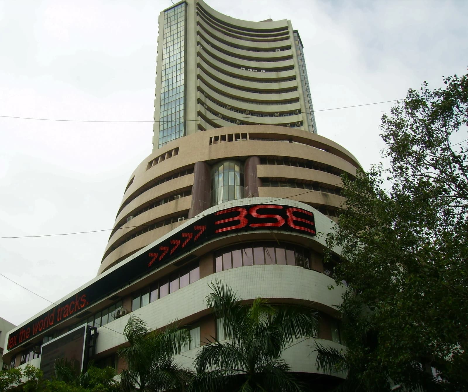 Bombay Stock Exchange building with BSE ticker on a cloudy day.