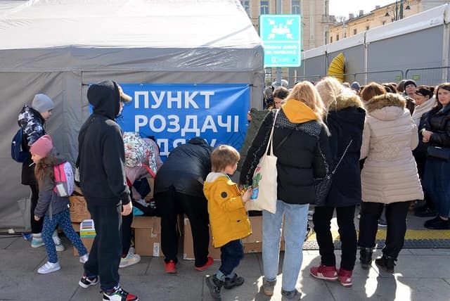 Ukrainian refugees, including children, gather at a distribution point in Kraków, Poland.