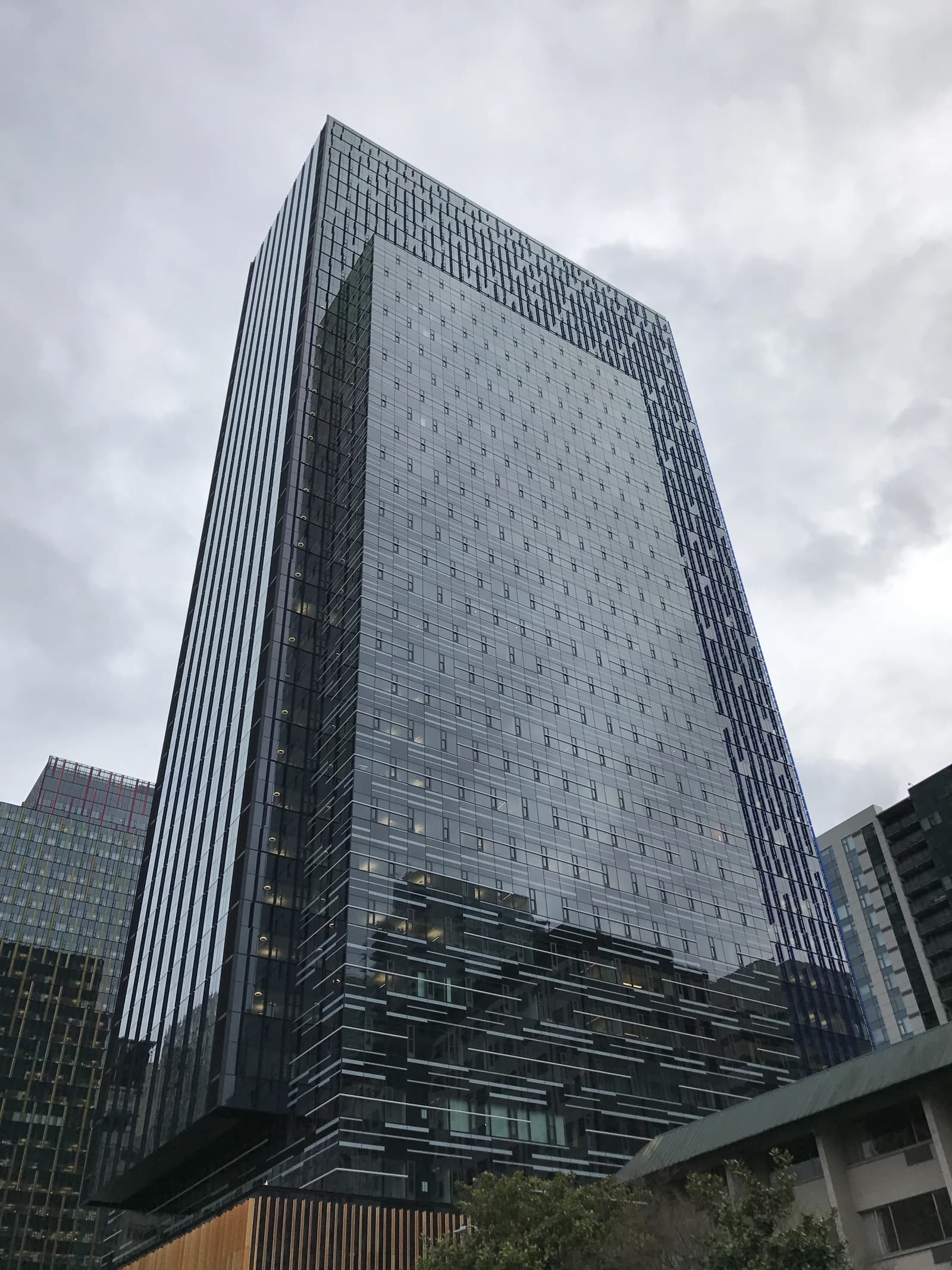Modern glass skyscraper in Seattle, Washington, viewed from below on a cloudy day.