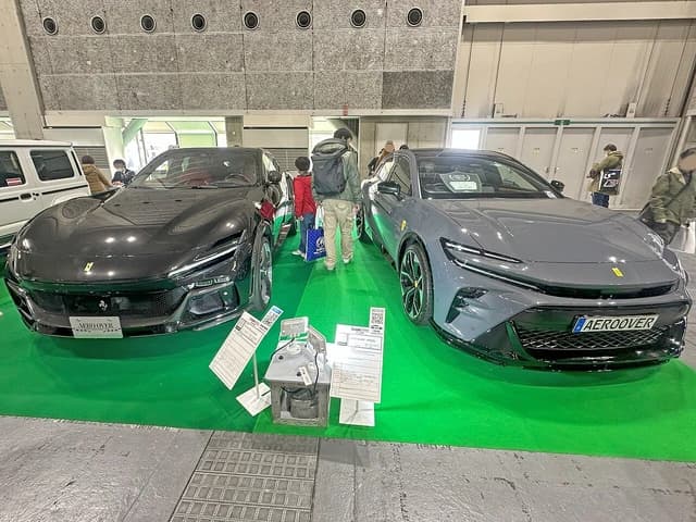 Two Ferrari Purosangue luxury SUVs displayed on a green carpet at an auto show.