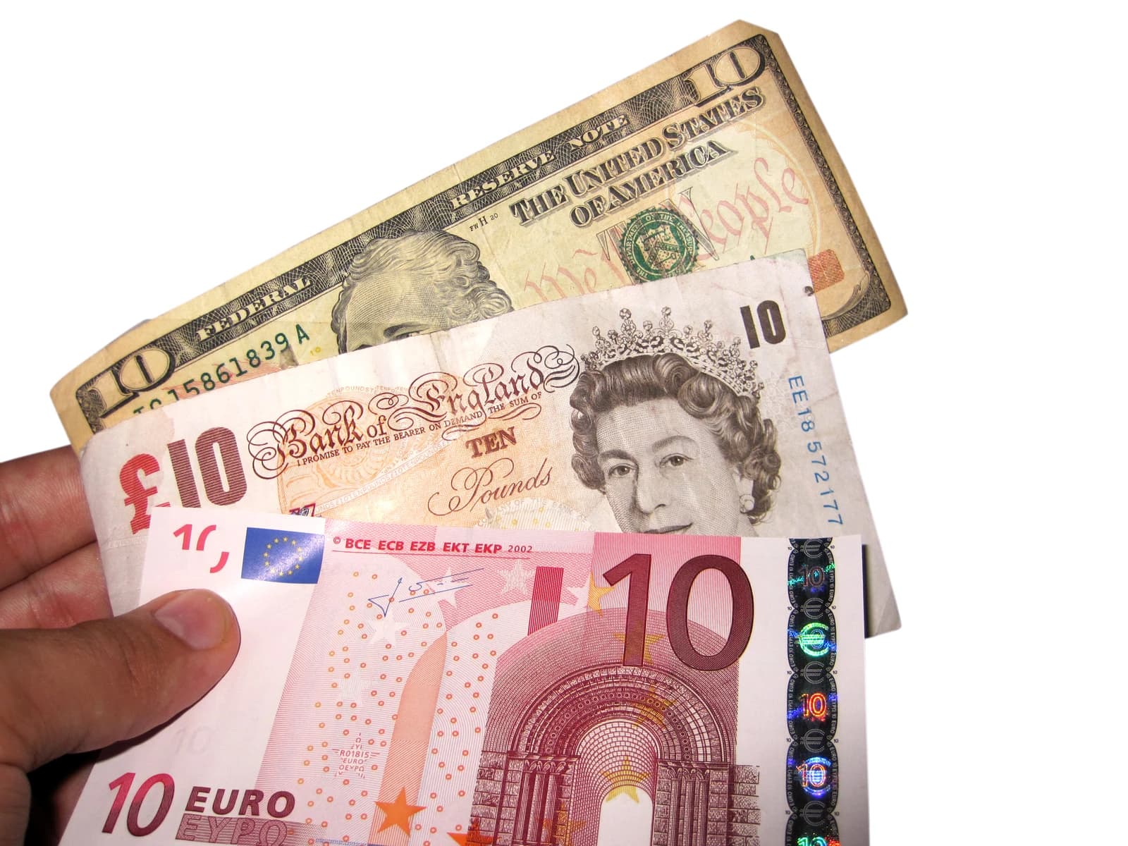 Hand holding ten-dollar bill, ten-pound note, and ten-euro note.