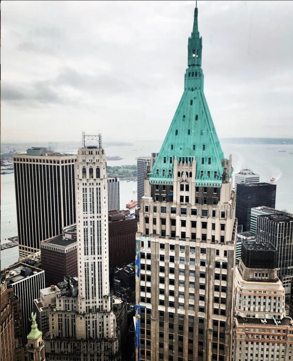 Aerial view of 40 Wall Street, a skyscraper with a green pyramidal roof, in New York City.