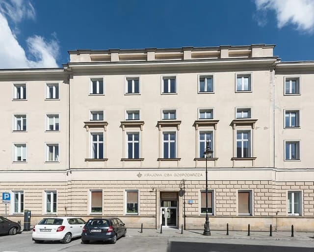 Exterior view of the Krajowa Izba Gospodarcza building in Warsaw, Poland, under a blue sky.
