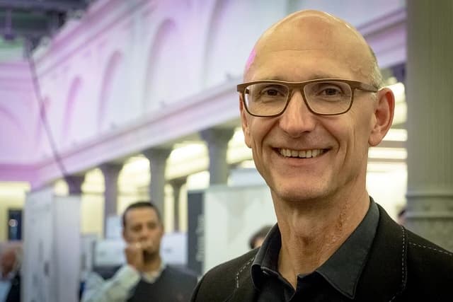 Timotheus Höttges, CEO of Deutsche Telekom, smiling and looking at the camera.