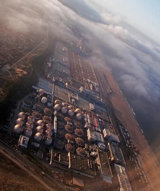 Aerial view of the Hyperion Sewage Treatment Plant through partial clouds.