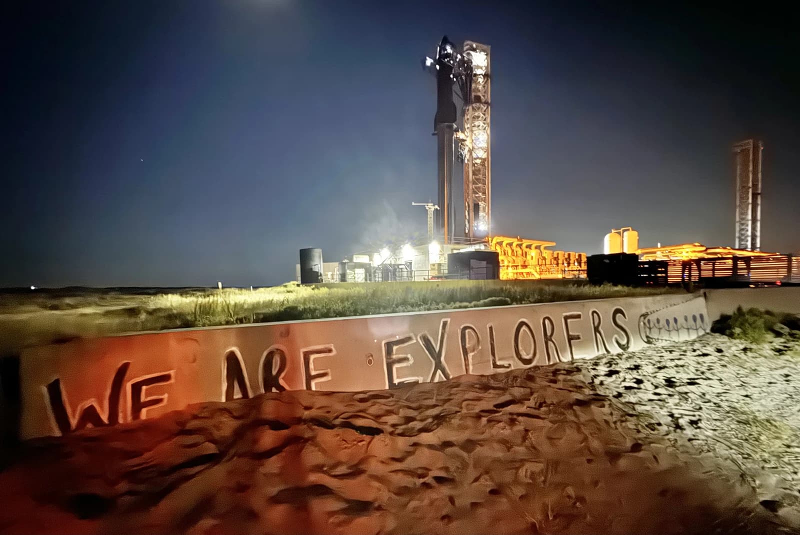 SpaceX Starship rocket on a launchpad at night under a dark sky.