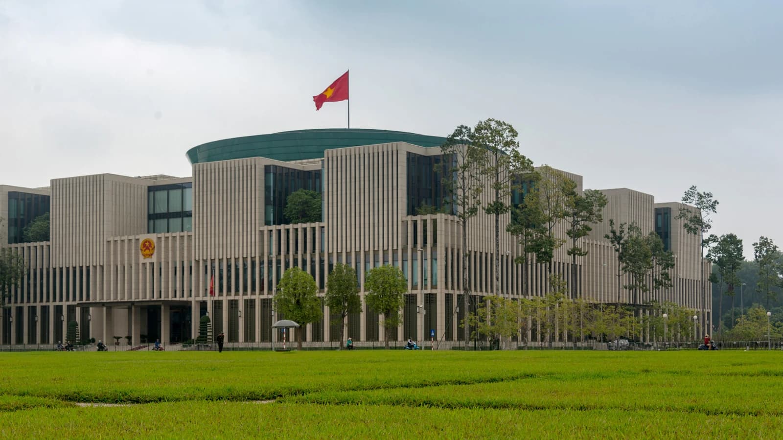 Exterior view of the National Assembly building in Hanoi, Vietnam, with a flag flying.