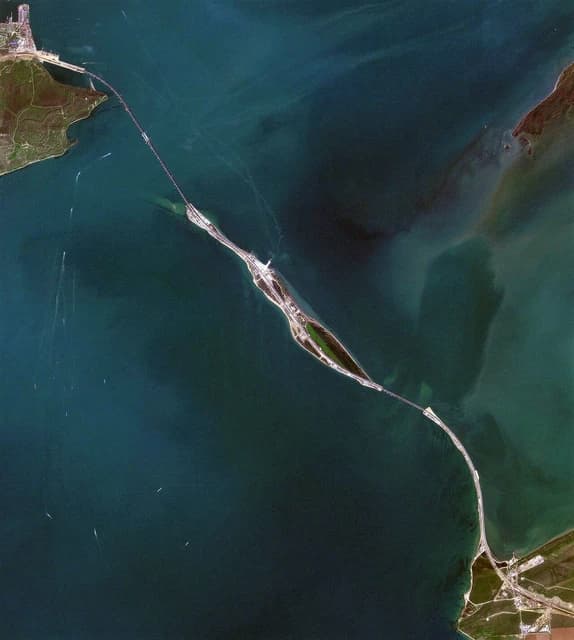 Aerial view of the Kerch Strait Bridge spanning a body of water, connecting two landmasses.