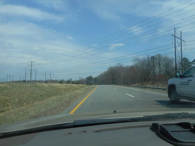 Power lines and utility poles line a highway in Athens, Virginia.