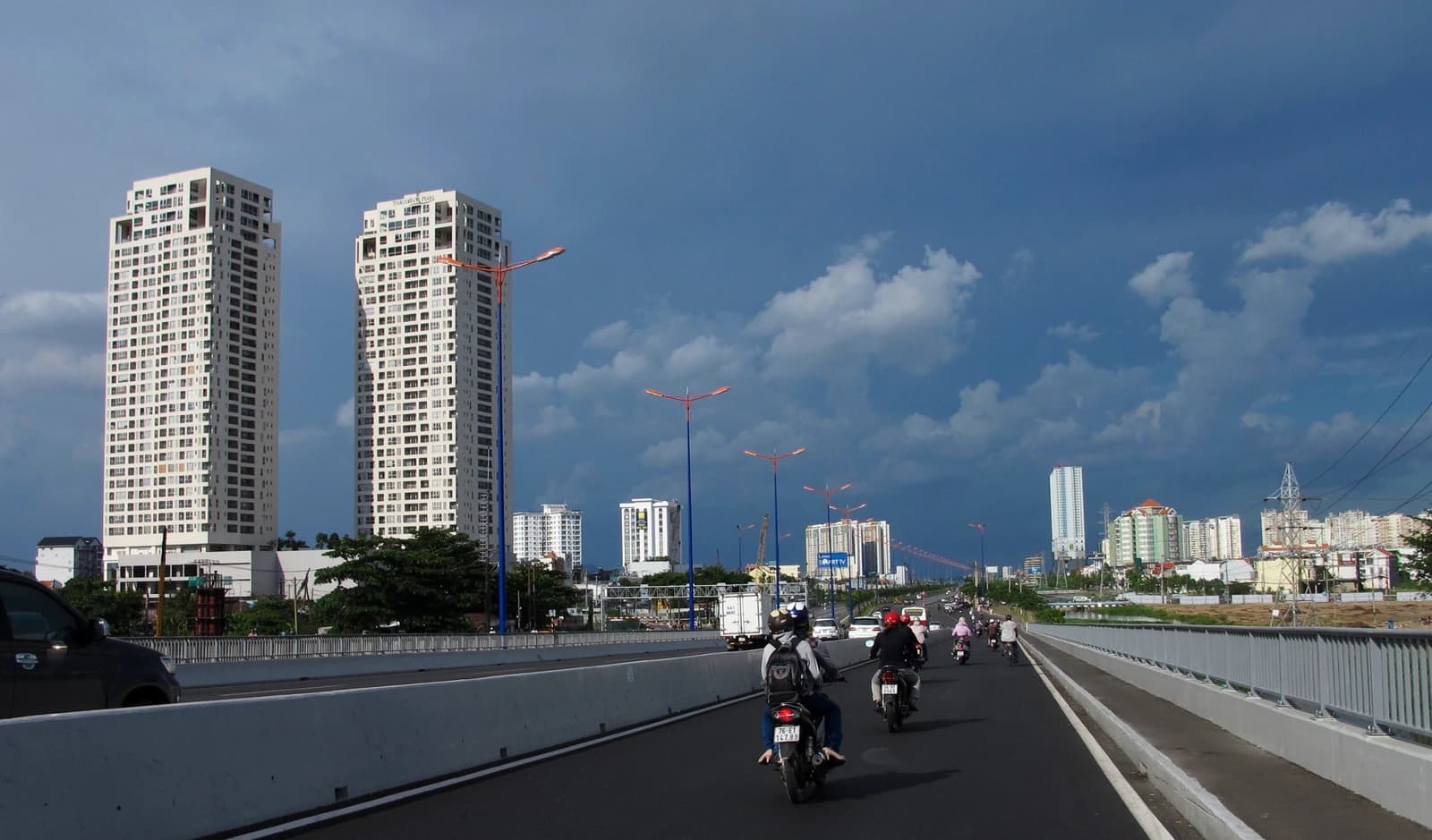 Cityscape of Ho Chi Minh City with apartment buildings and a busy highway.