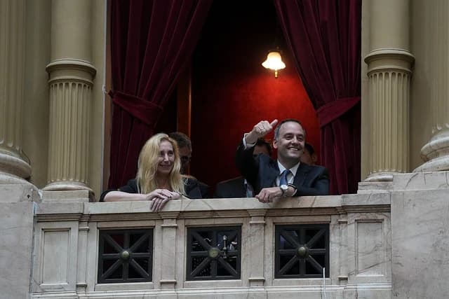 Karina Milei, general secretary of the Presidency, and Manuel Adorni, presidential spokesperson, on a balcony.