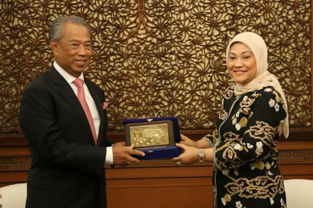 Ida Fauziyah and Muhyiddin Yassin exchanging a commemorative plaque.