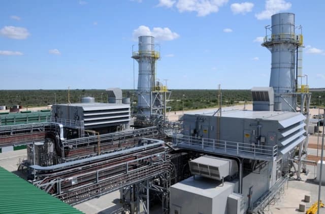 Overview of a gas turbine power plant facility with multiple stacks and industrial equipment.