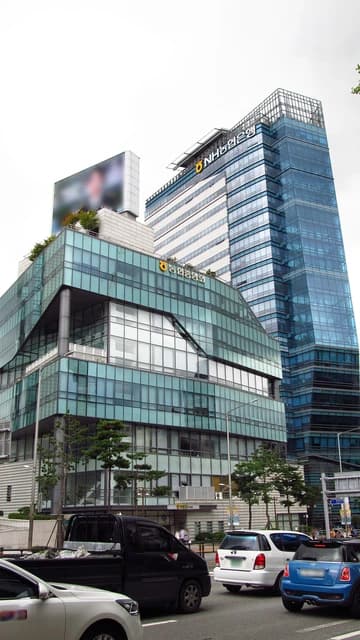 NH Nonghyup Bank building with blue and green glass facades in an urban area.