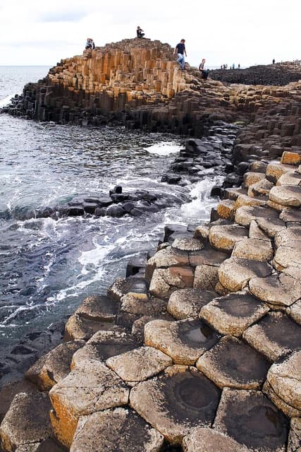 Travelers exploring the Giant's Causeway, a natural rock formation in Northern Ireland.