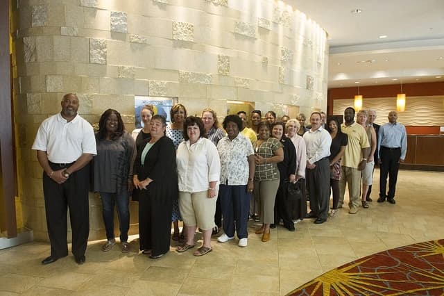 Group of diverse professionals from the Office of Human Resources standing together indoors.