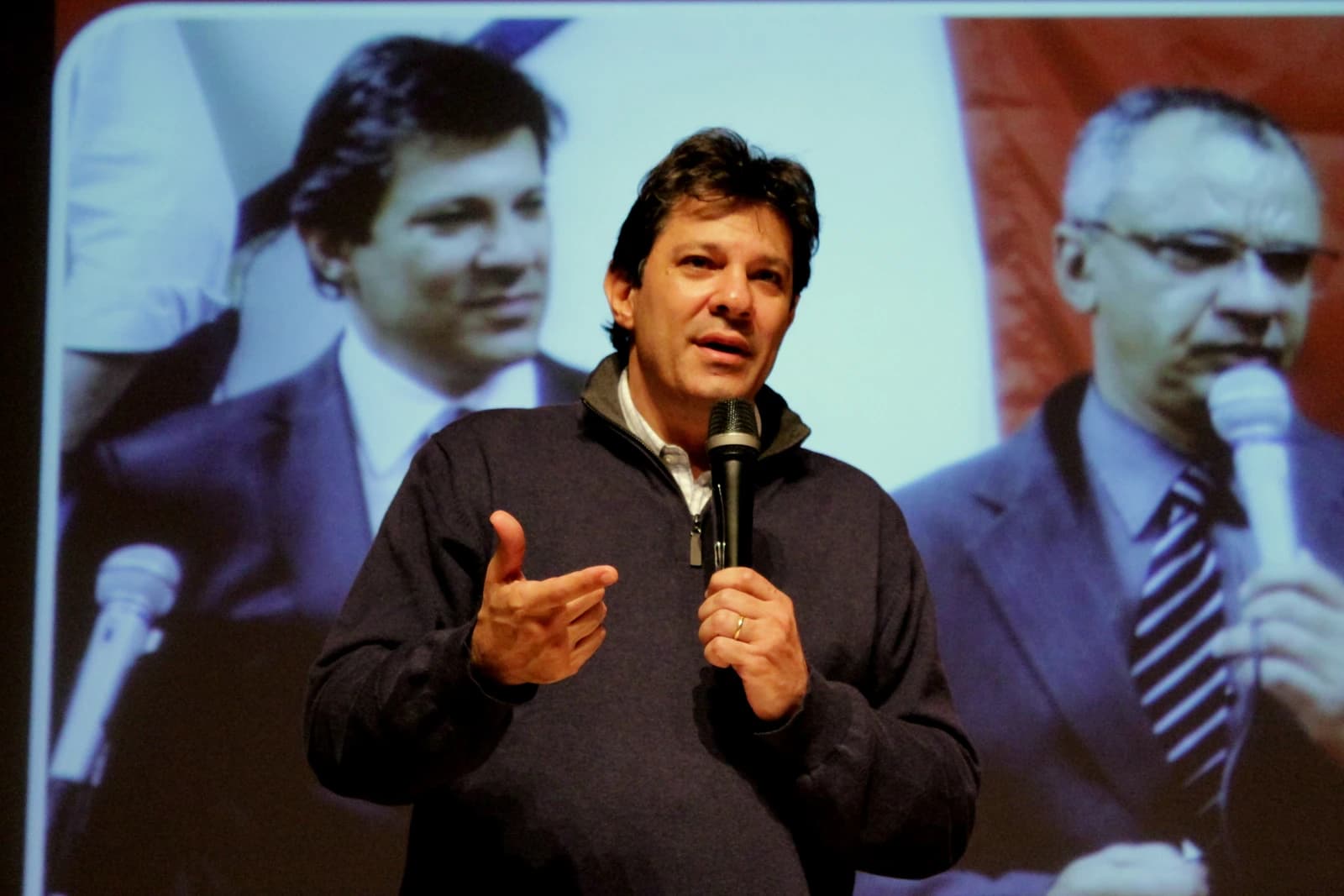 Fernando Haddad, Brazilian politician, speaking into a microphone at an event.