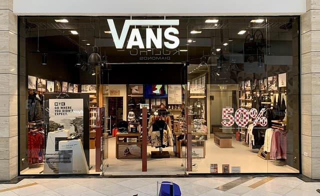 Vans store entrance with a 50% sale sign visible in a shopping mall in Bucharest.
