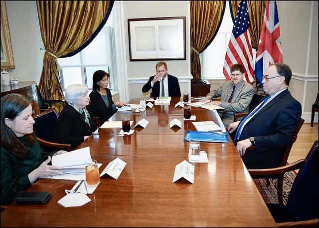 Janet Yellen, former US Treasury Secretary, and Andrew Bailey, Governor of the Bank of England, seated at a long conference table.